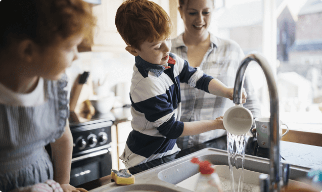small-boy-washing-up-with-two-women